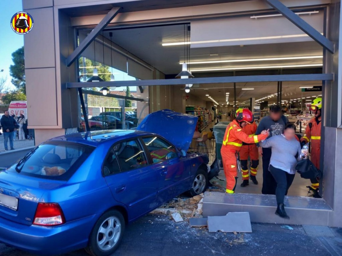 Un coche se ha emporado en la fachada de un supermercado de Burjassot